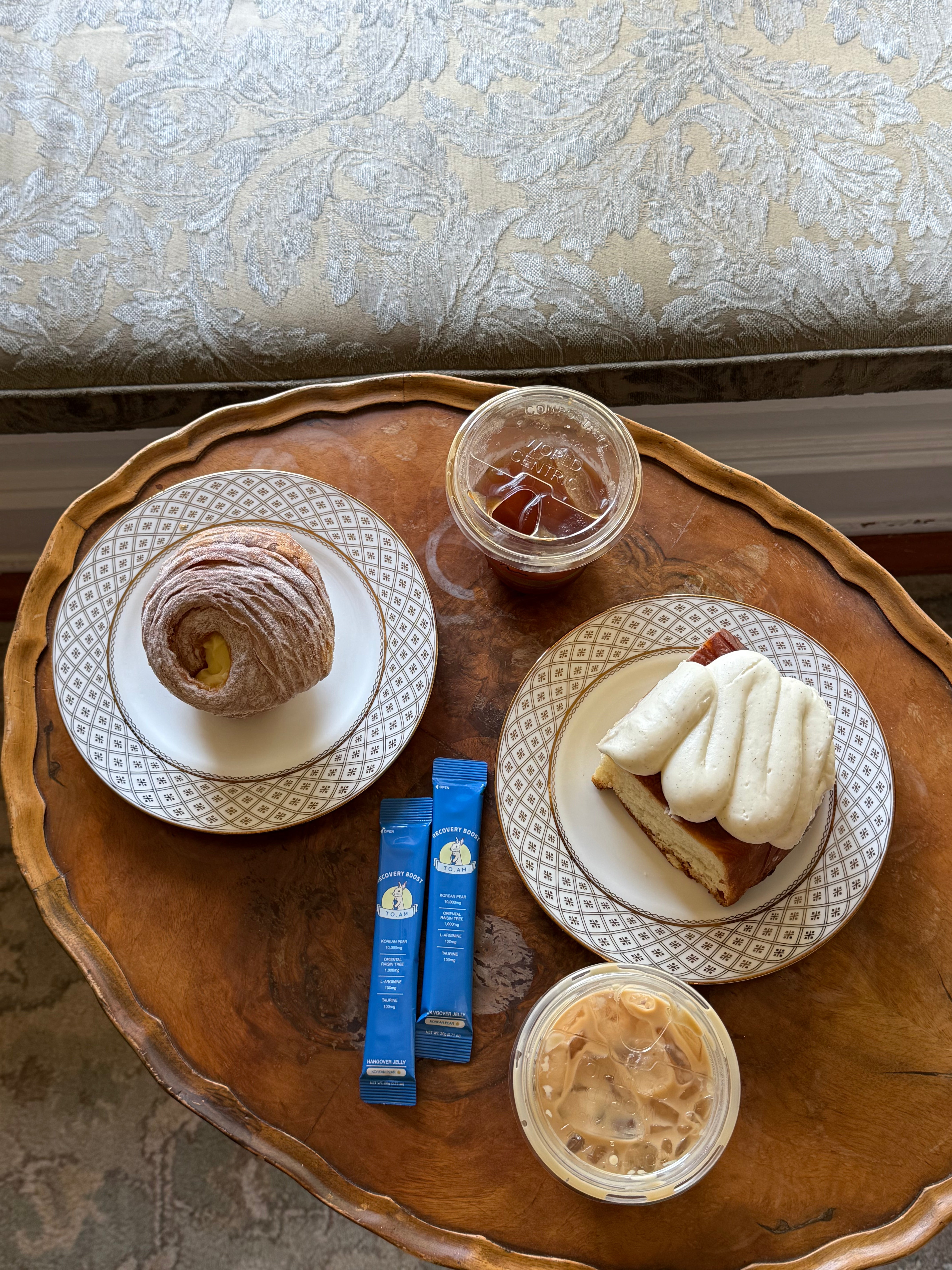 Tray with pastries, coffee, and TO. AM jelly stick on a textured surface